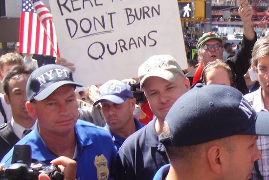 Unidentified man in baseball cap, who burnt Koran, escorted by NYPD